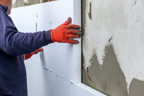 Installation of Styrofoam Insulation Sheets on House Facade Wall for Thermal Protection